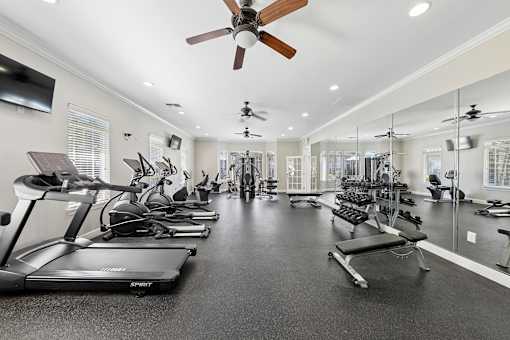 A spacious gym with treadmills, exercise bikes, and other equipment.