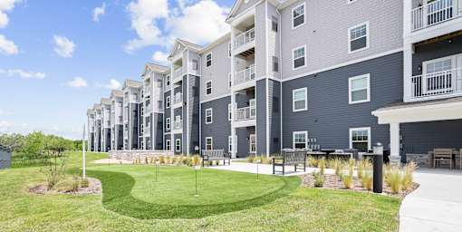 A large grassy area in front of apartment buildings.