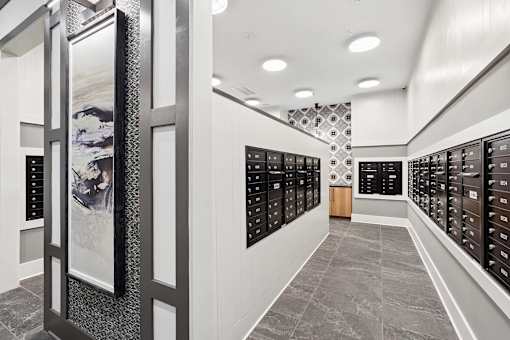 A hallway with a series of lockers on the right and a framed picture on the left.