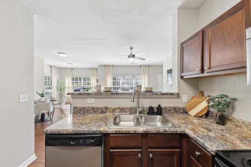 A kitchen with granite countertops and wooden cabinets.
