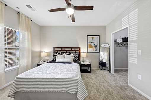 A bedroom with a large bed and a ceiling fan.