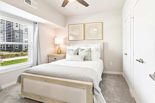 A bedroom with a bed, nightstand, and window.
