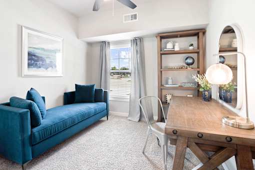 A living room with a blue couch and a wooden table.