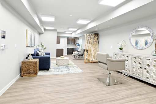 A well-lit, modern living room with a blue sofa, a wooden side table, and a white chair.
