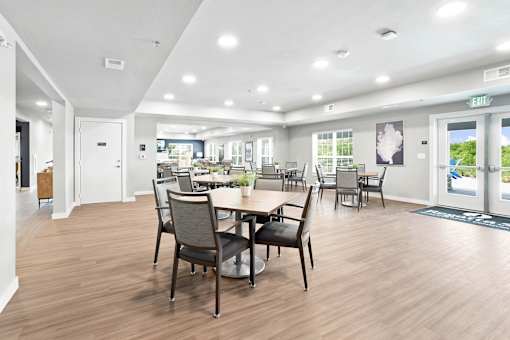 A dining room with a table and chairs.