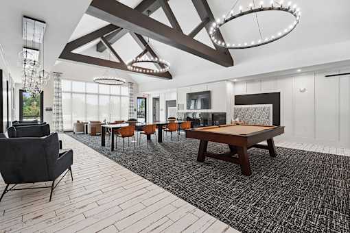 A large room with a pool table and chairs.