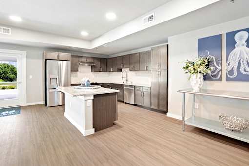 A modern kitchen with a wooden floor and white appliances.
