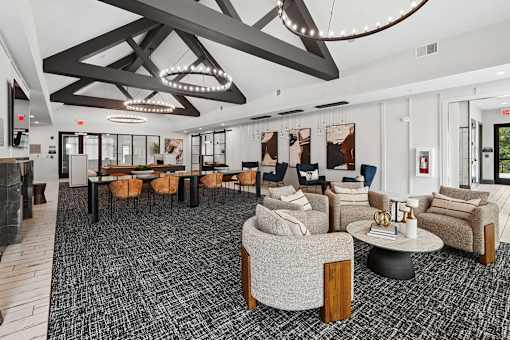 A large, modern room with a black and white carpet and a variety of seating options.