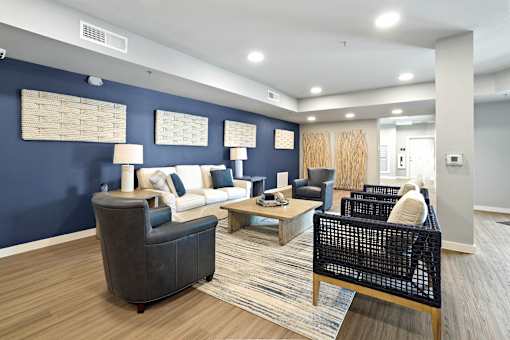 A living room with a grey sofa, a black wicker chair and a wooden coffee table.