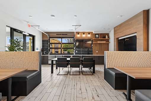 A modern dining area with a long table surrounded by black chairs and wooden benches.