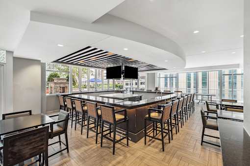 A modern bar with wooden chairs and a counter.