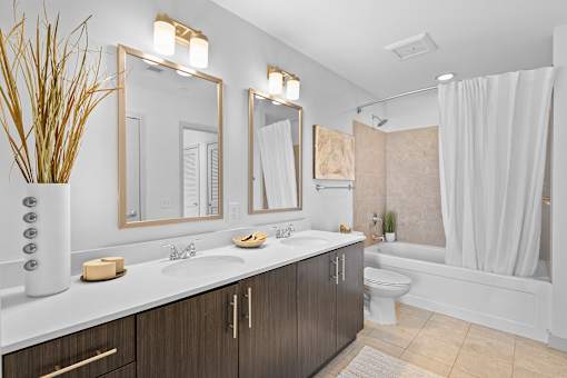 A modern bathroom with a white sink and brown cabinets.