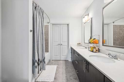 A bathroom with a white sink and a white rug.