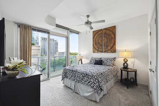 A bedroom with a large bed and a ceiling fan.
