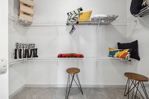 A room with a white wall and a grey carpet.