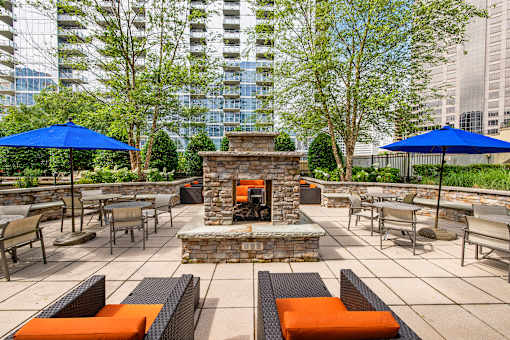 A patio with a fireplace and seating area.