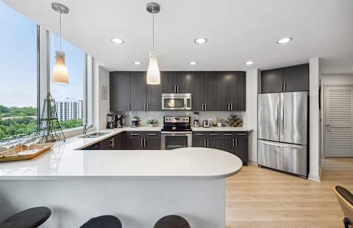 A modern kitchen with a large island and a view of the city.