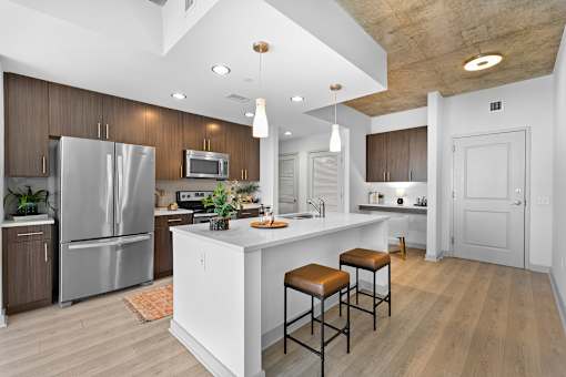 A modern kitchen with a white island and wooden cabinets.