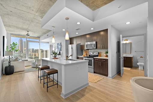 A modern kitchen with a bar area and a view of the city.