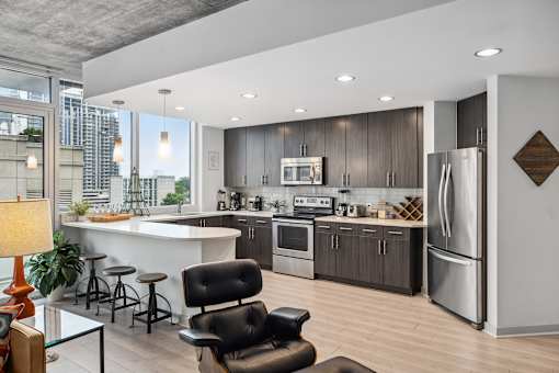 A modern kitchen with a bar area and a refrigerator.