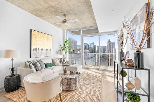 A living room with a large window overlooking a city skyline.