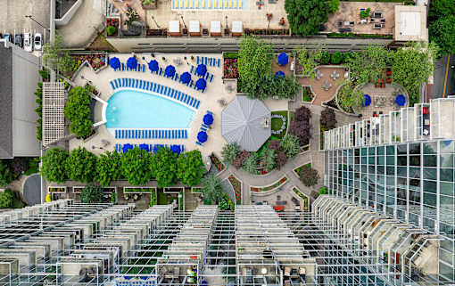 A large outdoor swimming pool surrounded by sun loungers and umbrellas.