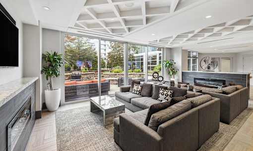 A modern living room with a large grey sofa and a flat screen TV.