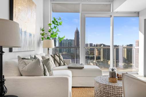 A living room with a large window overlooking a city skyline.