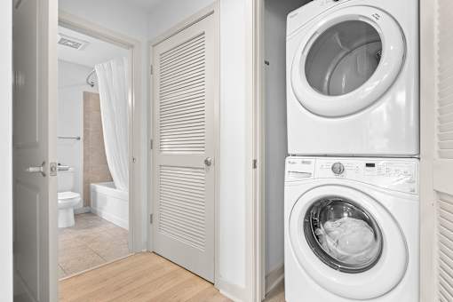A white washing machine is in a laundry room.