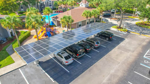 a row of cars parked under solar panels in a parking lot