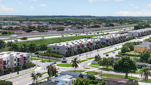 A view of a residential area with apartment buildings and palm trees.