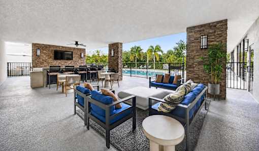 A living room with a television and a pool outside.