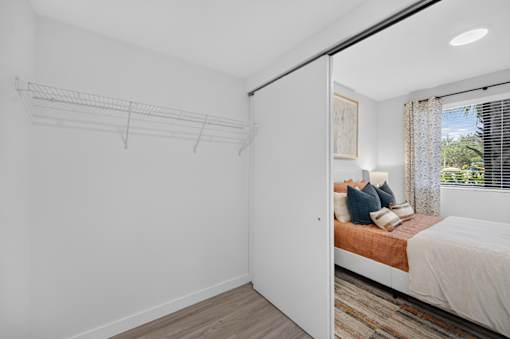A bedroom with a bed, pillows, and a window with curtains.