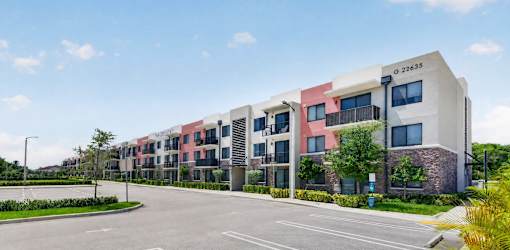 A modern apartment building with a mix of pink, white, and brown colors.