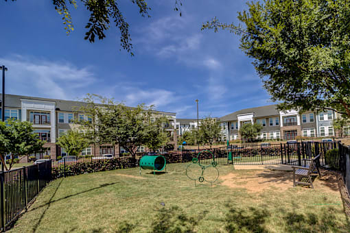 A playground with a green slide and a brown bench.