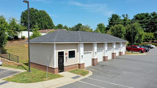 A small building with a parking lot in front.
