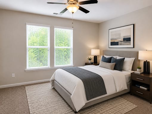 A bedroom with bed and painting with double window natural lighting
