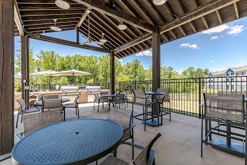 A patio with a table and chairs under a roof.