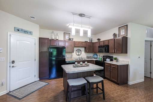 A kitchen with a table and chairs in the middle of it.