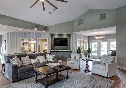 A living room with a grey couch, a wooden coffee table, and a flat screen TV.