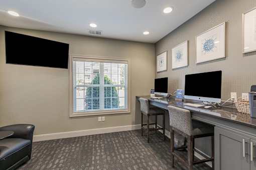A room with a desk, chairs, and a window.