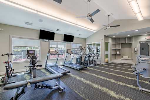A gym with a variety of equipment including treadmills, exercise bikes, and weight machines.