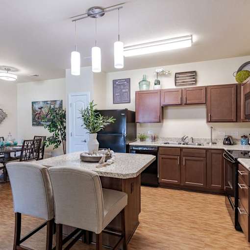 A kitchen with brown cabinets and a black refrigerator.