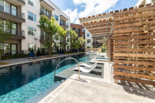 A pool with a slide and a wooden fence.