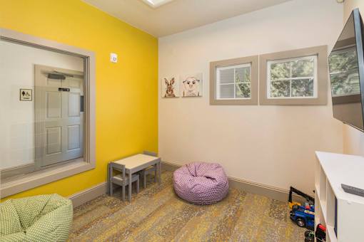 A room with a yellow wall and a purple bean bag chair.