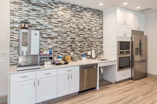 A kitchen with a stone wall and stainless steel appliances.