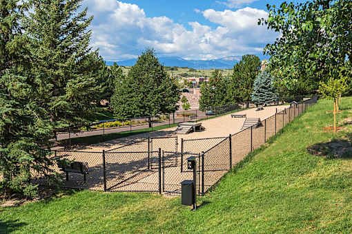 A playground with a fence and slide.