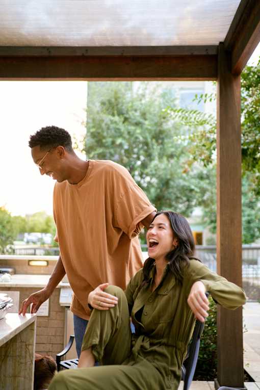 a man and a woman sitting in a rocking chair on a porch