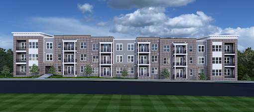 Nashville, TN, Luxury Apartments Near Country Music Hall of Fame and Museum - Crest at Stones Branch - Street View of Property Highlighting Concrete Pathway, Manicured Front Lawn, Private Patios and Balconies, Wooded Area, and Open Grass Field.
