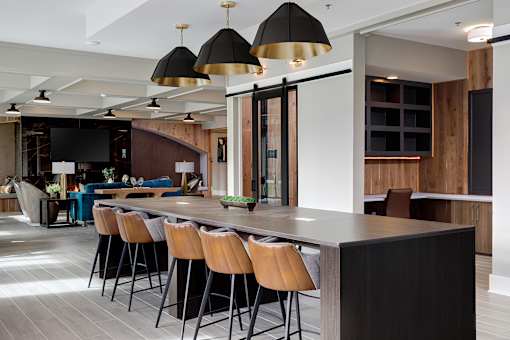 A modern kitchen with a long island and bar stools.